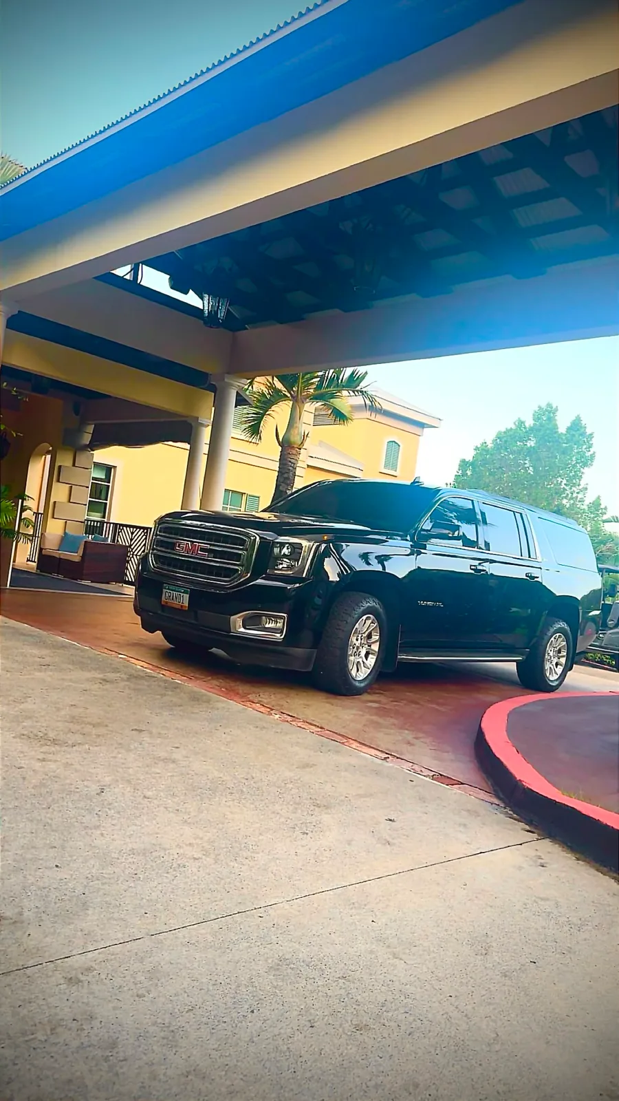 Black GMC Yukon XL Denali arriving under a resort entrance on St. Thomas